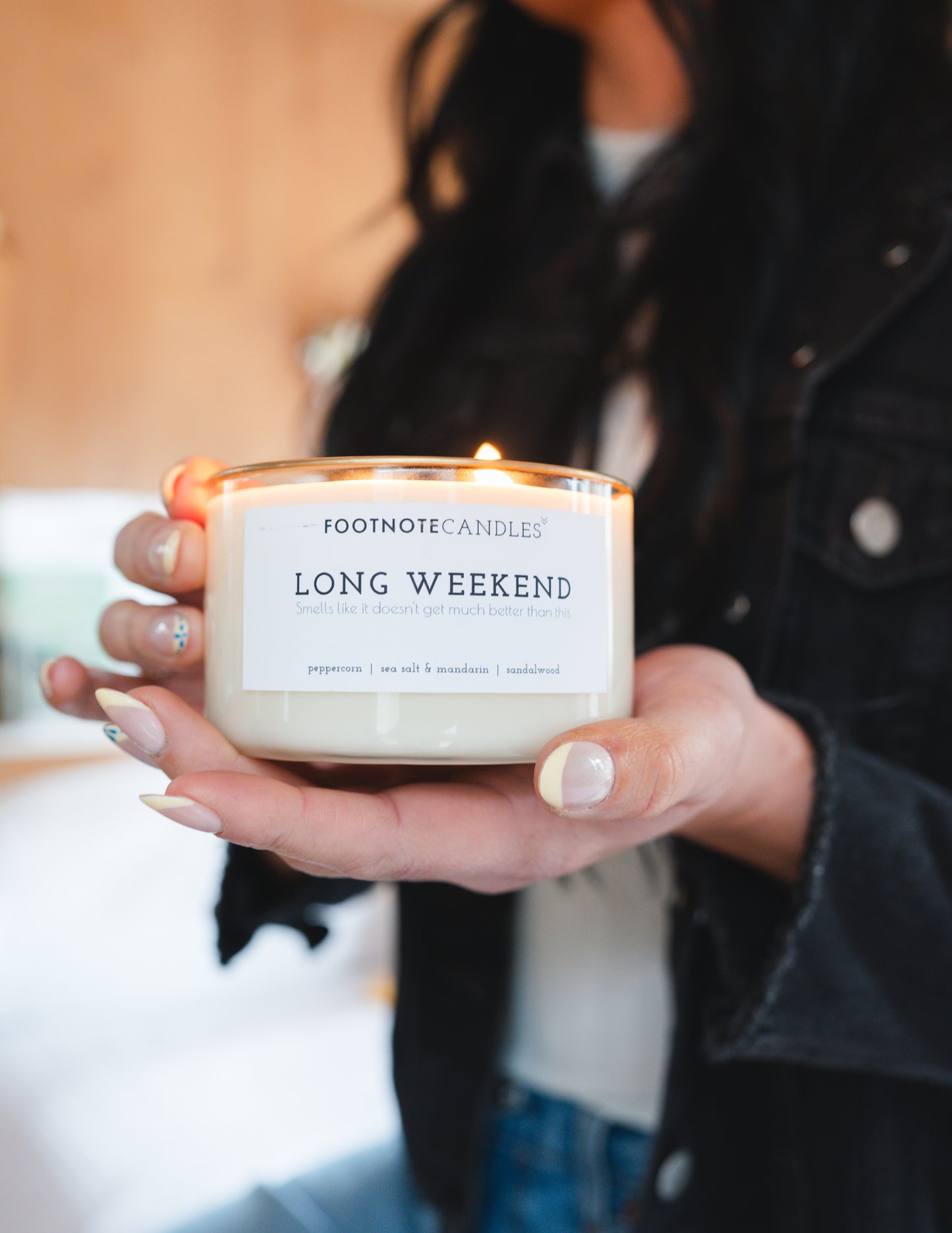 Long Weekend Candle from Footnote Candles, being held by a woman.