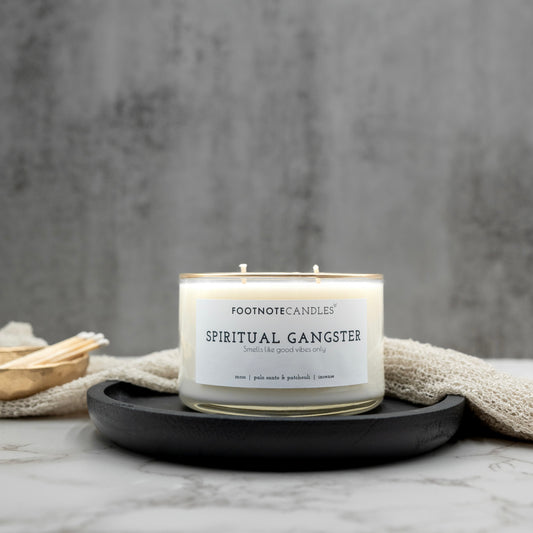 Spiritual Gangster Candle from Footnote Candles. Candle with hand painted gold rim, on black tray.