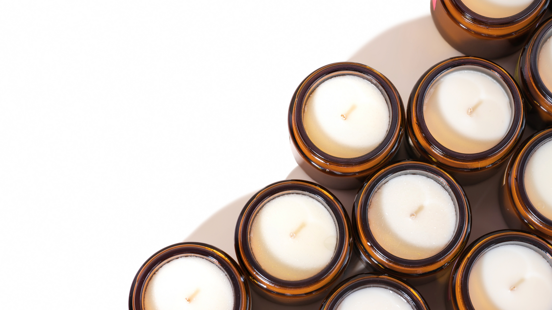 Photo of multiple unlit candles in amber glass jars