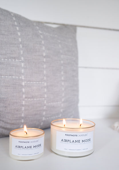 Airplane Mode Candles, full size and mini. Side by side on white counter with gray fabric accent.