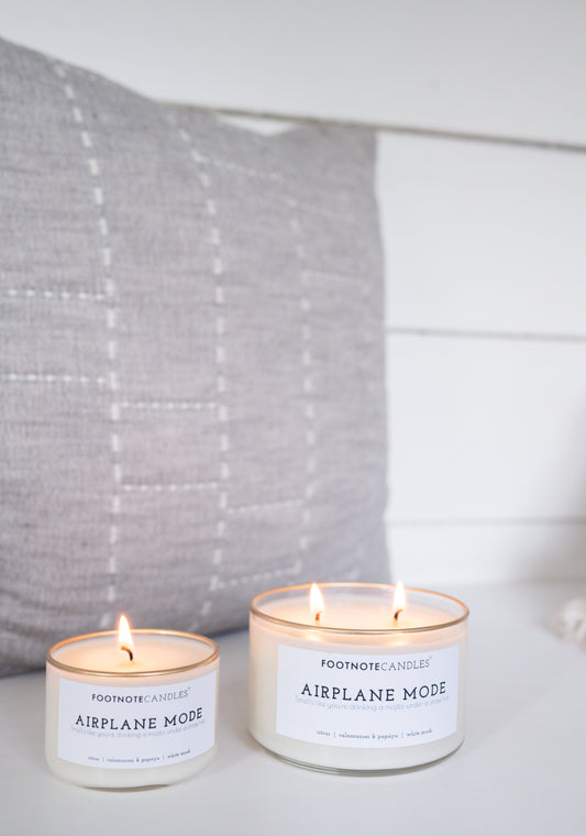 Airplane Mode Candles, full size and mini. Side by side on white counter with gray fabric accent.