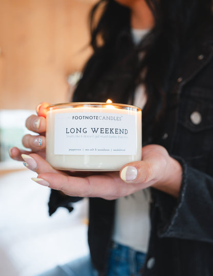 Long Weekend Candle from Footnote Candles, being held by a woman.
