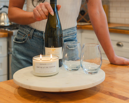 Meet Me at the Vineyard Candle from Footnote Candles, in kitchen with wine glasses and bottle of wine.