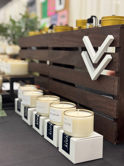 Mini Candles from Footnote Candles. Variety of scents sitting in market display.